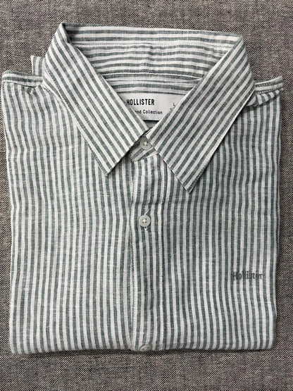 Folded Hollister striped shirt on a textured gray background
