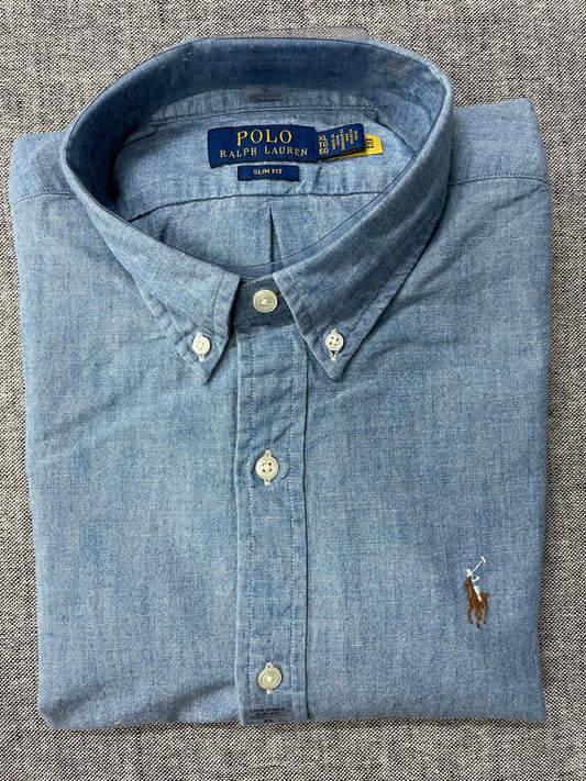 Folded blue Polo Ralph Lauren shirt on a textured surface